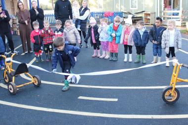 Park Lane Nursery pupil Kason cuts the ribbon on the enhanced outdoor learning area.